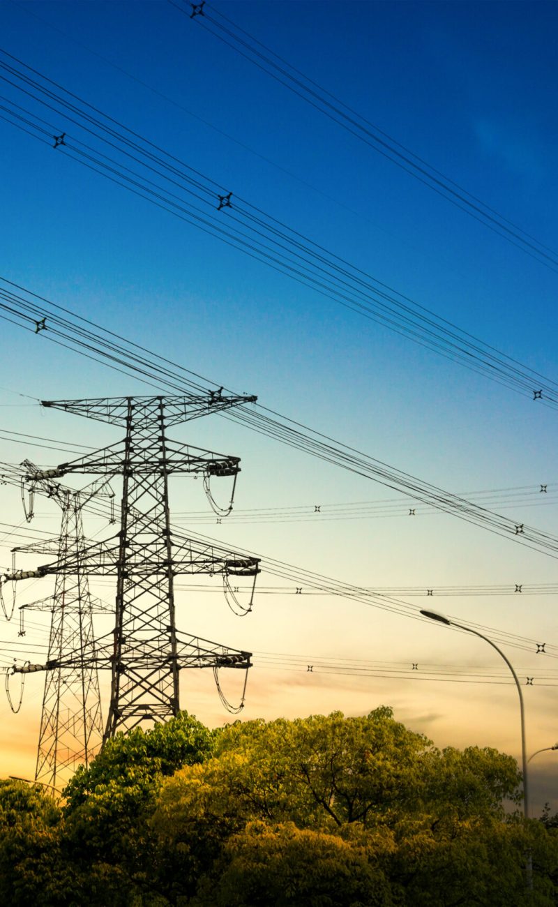 Sun setting behind the silhouette of electricity pylons